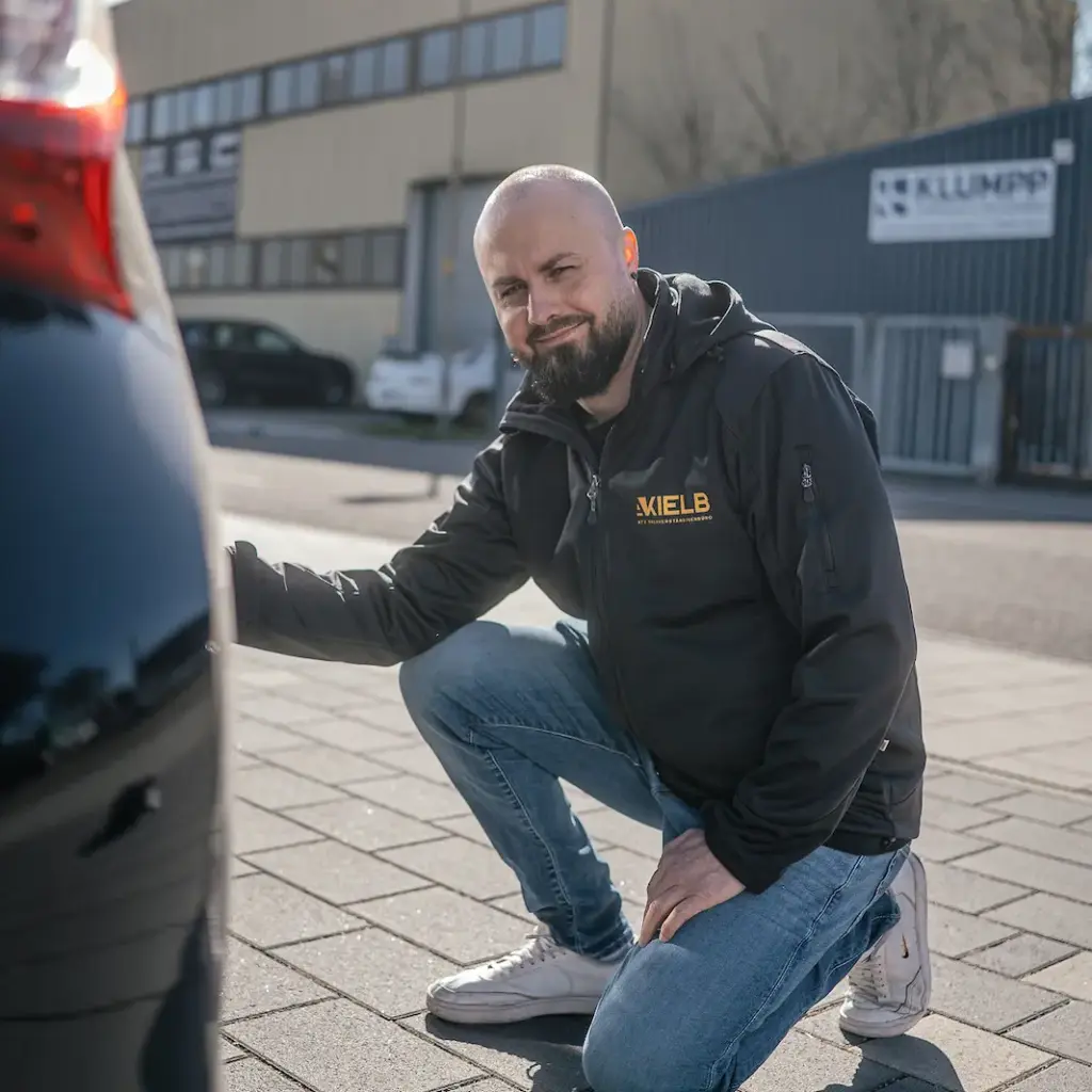 Kfz-Gutachter prüft die Heckstoßstange auf Unfallschäden – KIELB Sachverständiger bei der Schadenaufnahme