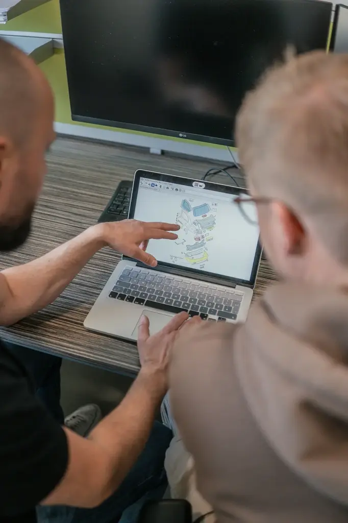 Kfz-Gutachter erklärt dem Kunden Details im Gutachten am Laptop – KIELB Sachverständiger bei der Beratung